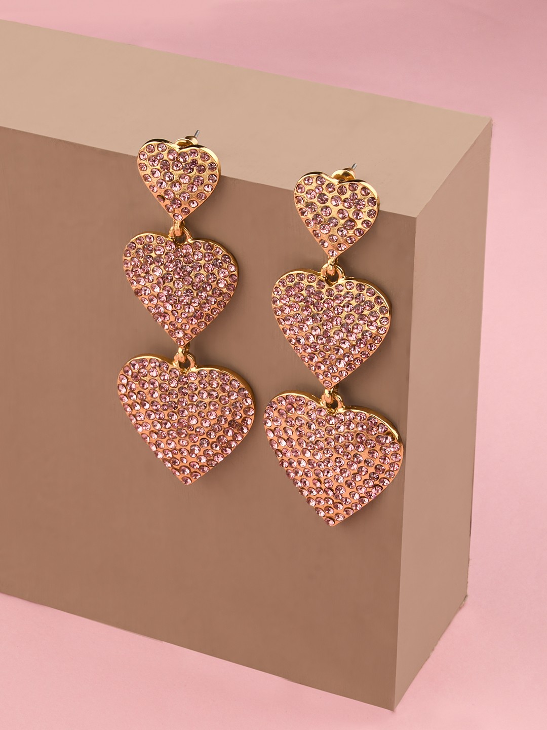 Gold toned pink stone studed triple heart dangler earrings