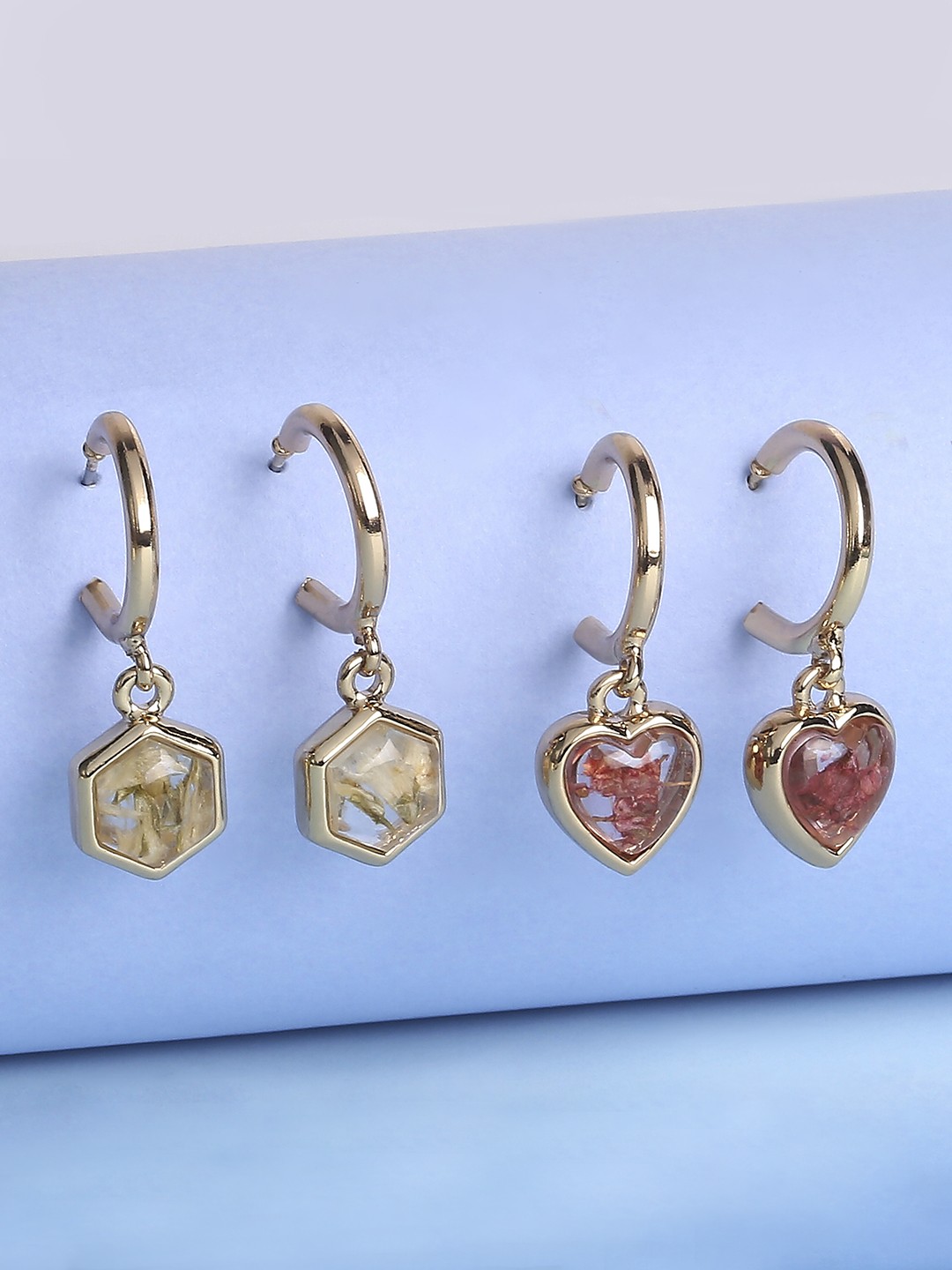 Set of 2 gold toned half hoop earrings with see through charms