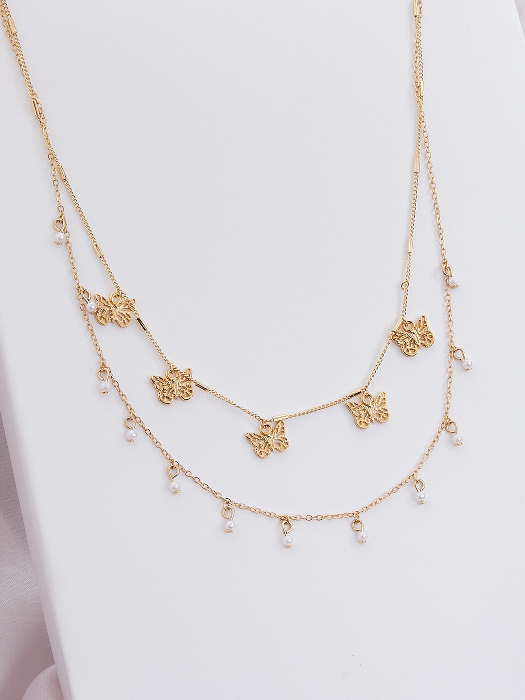 Gold toned two layered necklace with butterfly and pearl charms