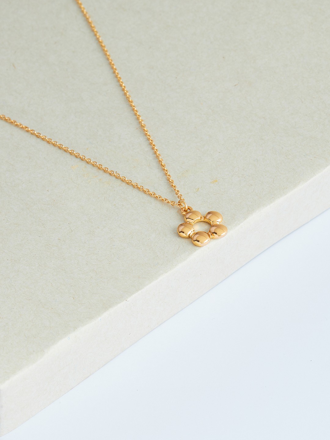Gold toned chain with flower charm pendant
