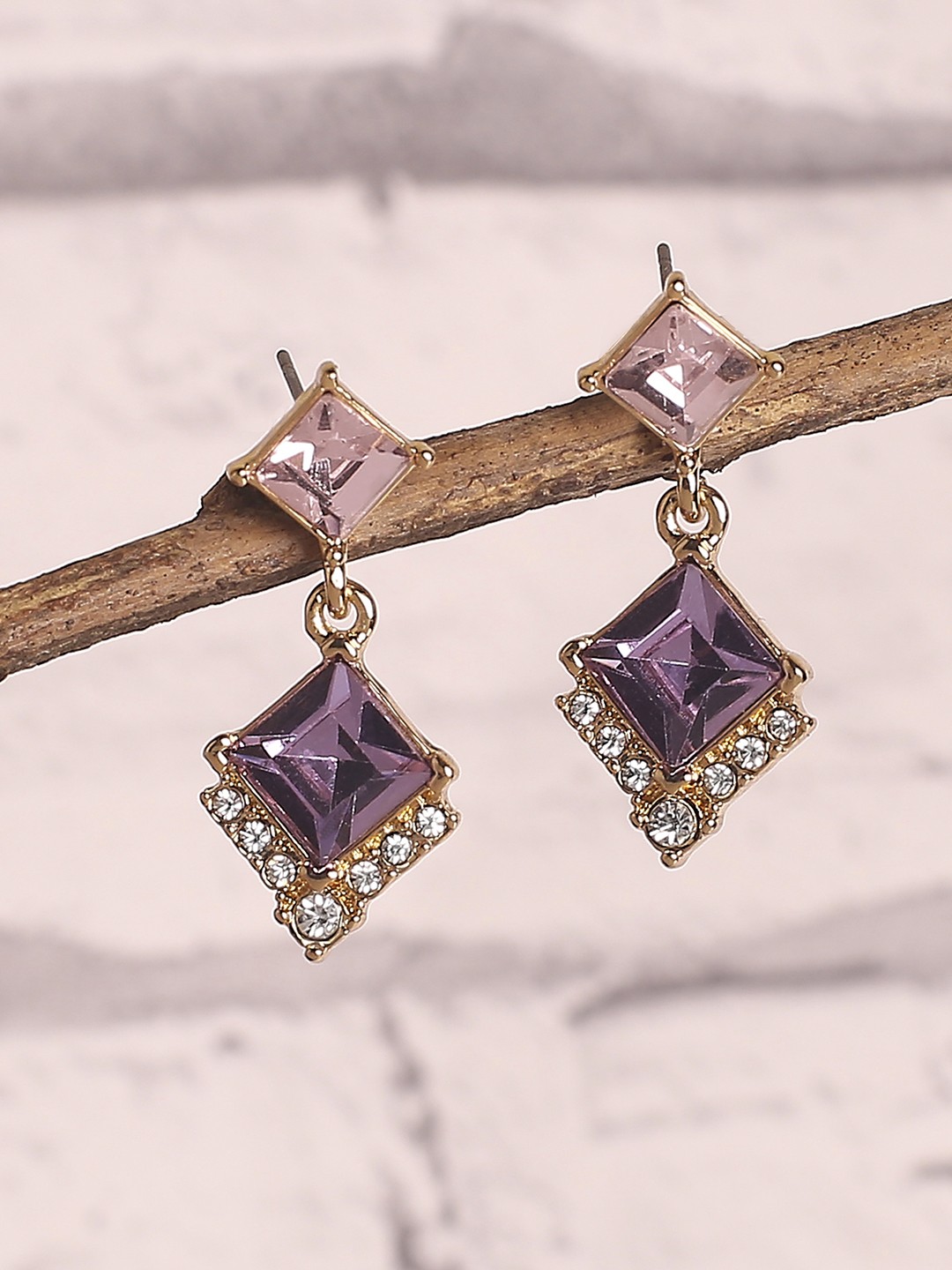 Gold toned drop earrings with purple stone
